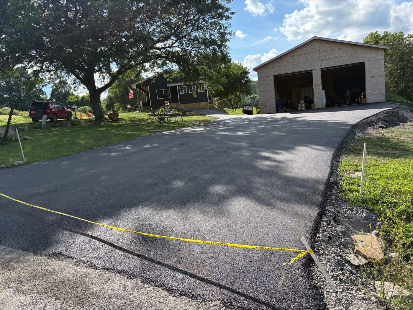 Finished asphalt driveway in front of a residential garage